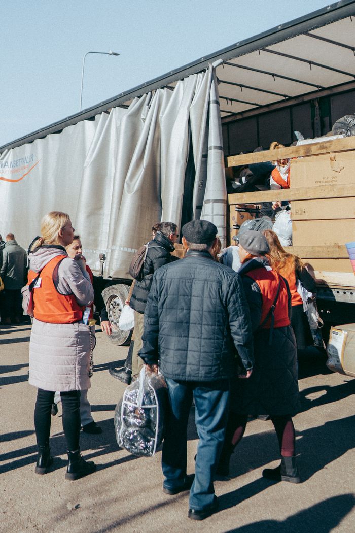 our-story-01 Volunteers distribute essential goods from a truck in Vilnius, Lithuania, showcasing community support.